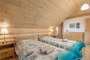 代尔尼采Mountain family home Nola Ivano的小木屋内一间卧室,配有两张床