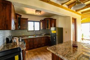 哈拉瓦科阿Rancho Batlle的厨房配有黑色冰箱和木制橱柜。