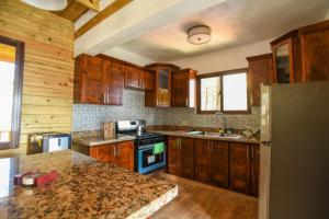 哈拉瓦科阿Rancho Batlle的厨房配有木制橱柜和花岗岩台面
