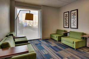 汉诺瓦巴尔的摩华盛顿国际机场韦斯特智选假日酒店的一间设有两张绿色椅子和一张桌子的等候室