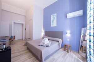 那不勒斯PC Boutique H Loggia, by ClaPa Group的一间卧室设有一张床和蓝色的墙壁