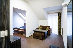 加尔沃林苏尔滨酒店的一间卧室配有一张床、一张沙发和一把椅子