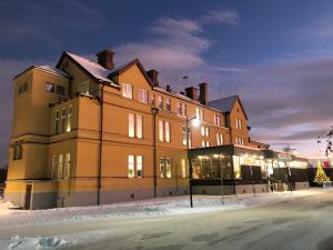 奥萨Orsa Järnvägshotell的一座大建筑物,在晚上下雪