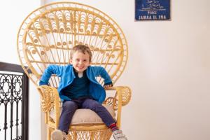 马拉喀什利马尔庭院旅馆的坐在藤椅上的男孩