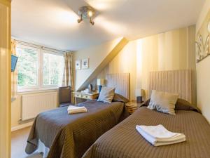 爱丁堡OYO Arden Guest House, Craigmillar Castle Edinburgh的酒店客房设有两张床和窗户。