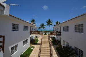 伊塔马拉卡Itamaracá Apartments的两座建筑之间的人行道,以海洋为背景
