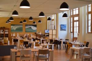 波尔多Hotel Saint Louis Beaulieu - Bordeaux的用餐室设有桌椅和窗户。