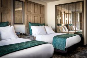 绿湾Lodge Kohler的酒店客房设有两张绿色床铺。