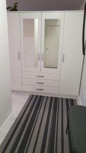 哈米纳Hamina Orange Apartments Kadetti 2的一间设有白色橱柜和条纹地毯的房间