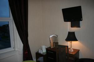 格文罗耶尔酒店的酒店客房设有一张桌子和一台墙上的电视。
