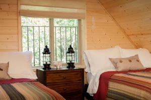 CoramThe Ridge At Glacier - Luxury Cabins的一间卧室设有两张床和窗户。