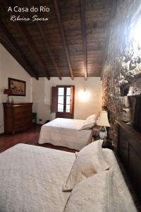 钱塔达A Casa do Río的一间卧室设有两张床和石墙
