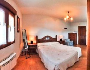 厄尔巴拉克El Mirador Apartamentos的卧室配有1张床、1张桌子和1把椅子