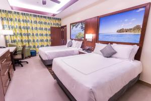 塞班冲浪者度假酒店的配有大窗户的酒店客房内的两张床