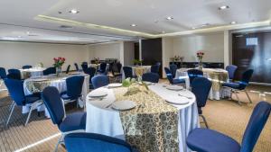 库利亚坎库利亚坎智选假日酒店的一间会议室,配有桌子和蓝色椅子