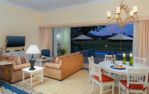 马萨特兰Pueblo Bonito Emerald Bay Resort & Spa - All Inclusive的客厅配有桌椅和电视。