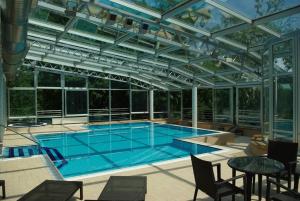 洛夫兰维拉别墅酒店 的一座带玻璃天花板的别墅内的游泳池