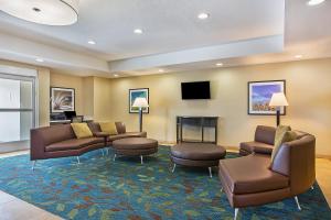 奥克格罗夫Candlewood Suites Fort Campbell - Oak Grove, an IHG Hotel的带沙发和椅子的等候室和壁炉