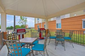 奥克格罗夫Candlewood Suites Fort Campbell - Oak Grove, an IHG Hotel的一个带桌椅和烧烤架的庭院