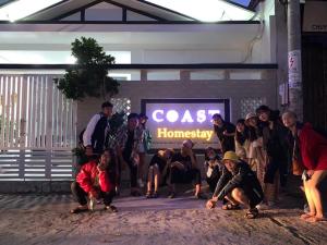 绥和市Coast Homestay的一群站在商店前的人