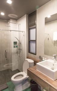 清迈罗德曼酒店的浴室配有卫生间、盥洗盆和淋浴。