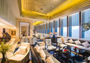 义乌义乌开臣国际酒店的酒店大堂设有沙发、桌子和窗户。