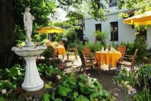 施莱茨Hotel Luginsland的花园设有雕像和桌椅