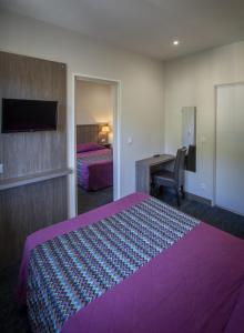 布里昂松布里松山酒店的酒店客房配有紫色的床和书桌