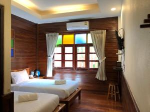 清刊Chiangkhan Hotel的一间卧室设有两张床和一个带彩虹的窗户。