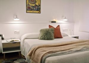 毕尔巴鄂ZUBIGANE apartamento junto a la Ría & Parking的一间卧室配有一张带枕头和桌子的床