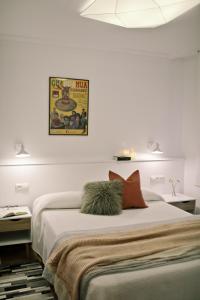 毕尔巴鄂ZUBIGANE apartamento junto a la Ría & Parking的白色卧室配有一张带两个枕头的大床