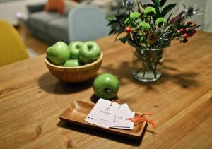 毕尔巴鄂ZUBIGANE apartamento junto a la Ría & Parking的一张桌子,上面放着一盘苹果和一碗鲜花
