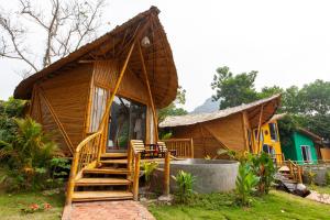 宁平Trang An Lamia Bungalow的一座带门廊和楼梯的小木房子
