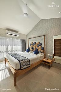 罗纳瓦拉Meritas Adore Resort的一间卧室配有一张带蓝色枕头的大床