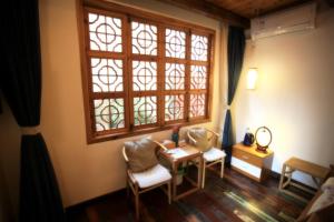 苏州苏州同里海棠花开乡愁客栈的客房设有桌椅和窗户。