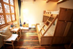 苏州苏州同里海棠花开乡愁客栈的客房设有两张双层床和一张桌子及椅子。