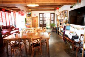 苏州苏州同里海棠花开乡愁客栈的用餐室配有木桌和椅子