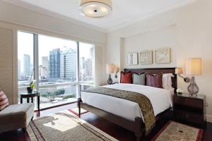 马尼拉Raffles Makati的一间卧室设有一张大床和一个大窗户