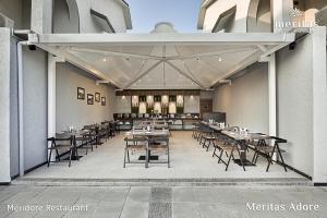 罗纳瓦拉Meritas Adore Resort的大楼内带桌椅的餐厅