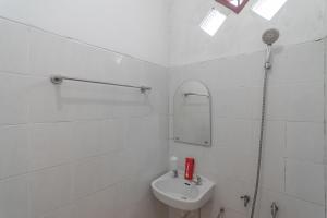 巴厘巴板RedDoorz Syariah near Terminal Batu Ampar 2的白色的浴室设有水槽和镜子