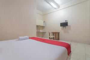 巴厘巴板RedDoorz Syariah near Terminal Batu Ampar 2的卧室配有白色的床和电视