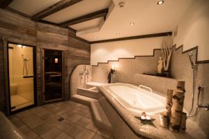 坎波图雷斯中心公寓式酒店的大型浴室设有浴缸和淋浴。