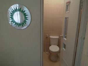 日惹Omah Ngadiwinatan Syariah的浴室设有卫生间和门上的镜子