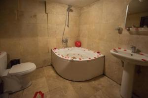 Guzelyurt卡拉曼利大厦酒店的带浴缸、卫生间和盥洗盆的浴室
