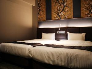 福冈Hotel Halrotto Fukuoka Hakata的一间卧室,配有两张床