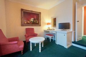 巴比松ARTEMIS SUITE的酒店客房配有带电视和椅子的书桌