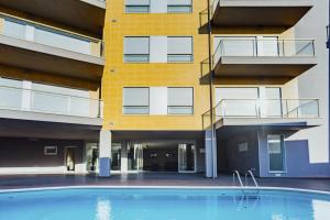圣马蒂纽·杜·波特Baia Residence 3 - Holiday Apartments - By SCH的一座大楼前空的游泳池