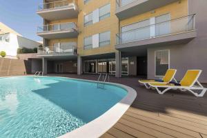 圣马蒂纽·杜·波特Baia Residence 3 - Holiday Apartments - By SCH的一座带两把椅子的游泳池以及一座建筑