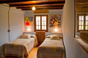 卢安科Casas Rurales Pradina I y II的带2扇窗户的客房内的2张床