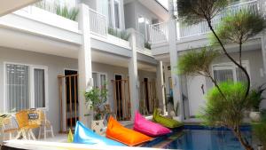 吉利特拉旺安Mantra Gili的游泳池旁的一栋带色彩缤纷枕头的建筑